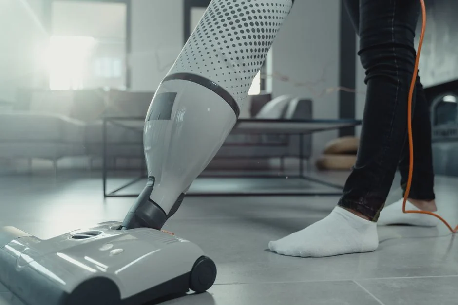A cleaner using a vacuum in a stylish indoor setting, highlighting cleaning tools and methods.